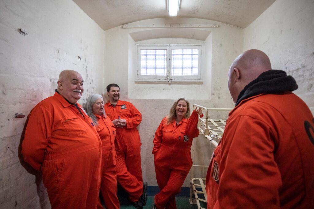 Shrewsbury Prison escape room with people in orange prison jumpsuits. A fun idea for a date in Shrewsbury